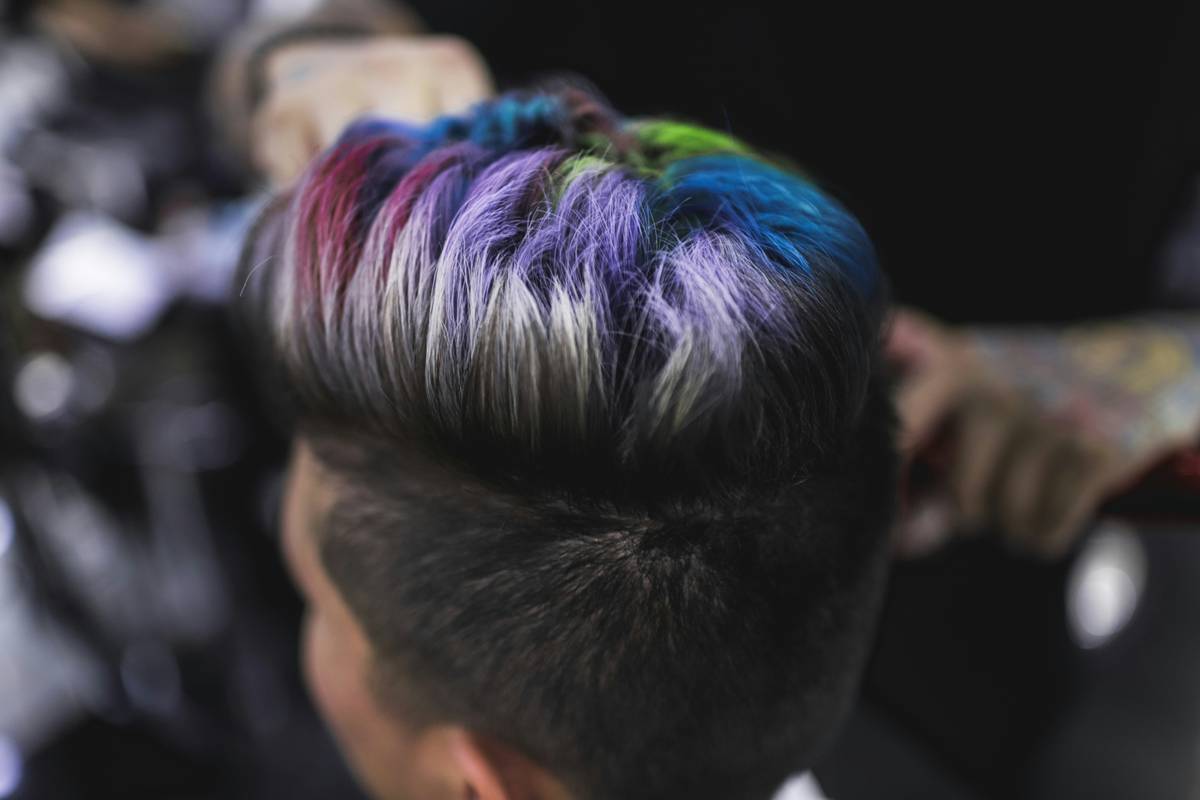 Professional stylist applying ombre hair technique with diagonal sectioning and feathering brush