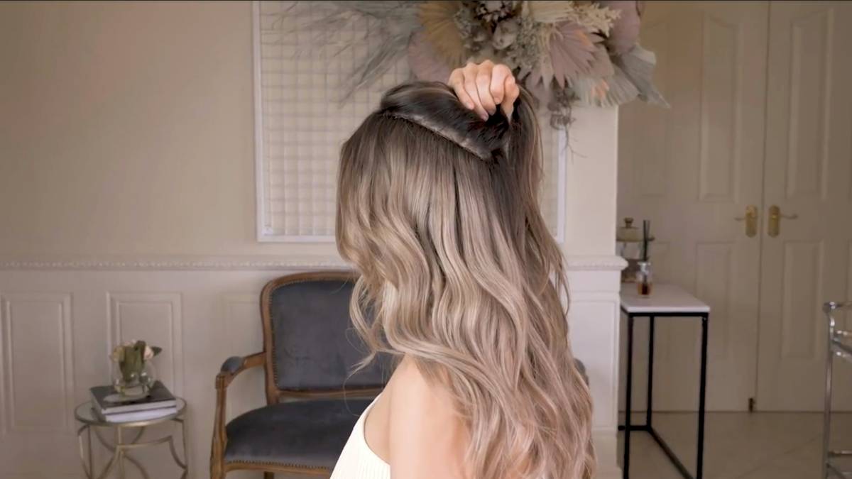 Woman with seamless ombre hair shade transitioning from dark brown roots to honey blonde ends