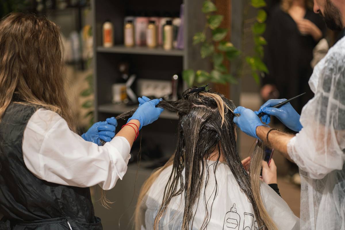 Close-up of model showing seamless professional ombre service from dark roots to golden ends
